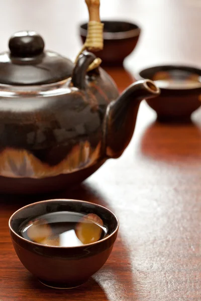 Xícara de chá e bule, mesa de madeira — Fotografia de Stock