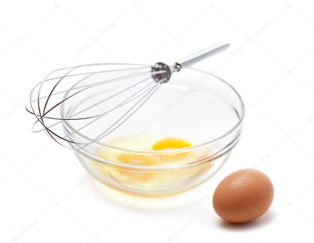 Wire whisk and brown eggs, isolated on white.