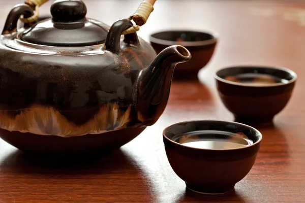 Xícara de chá e bule, mesa de madeira — Fotografia de Stock
