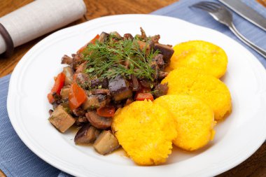 Polenta slices with vegetable stew clipart