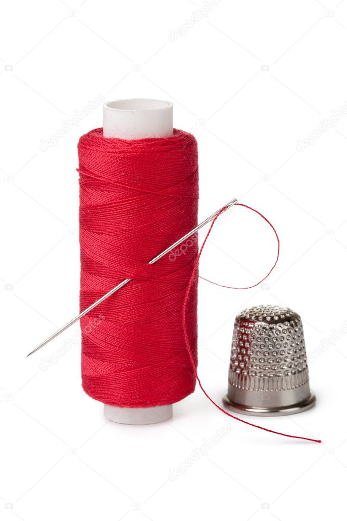 Red bobbins of thread and needle