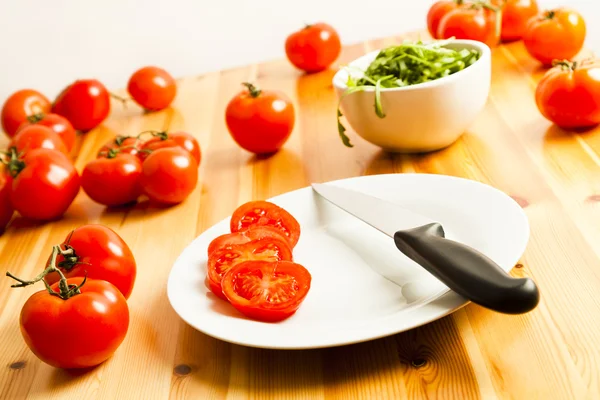 Üzüm domates, roka ve bıçak, mutfak masasının dilimlenmiş — Stok fotoğraf