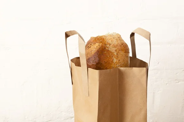 Bruin brood in een papieren drager zak — Stockfoto