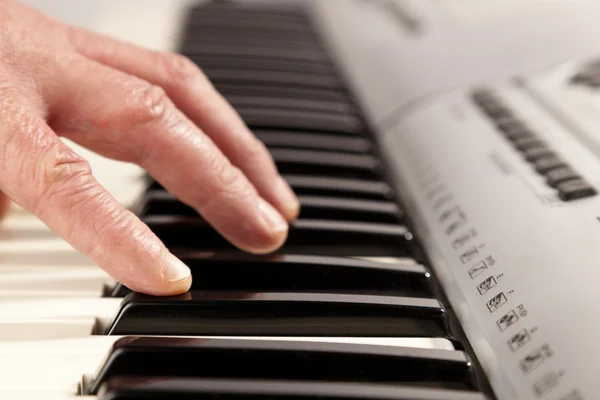 Pessoa idosa aprendendo a tocar um teclado moderno Fotografia De Stock