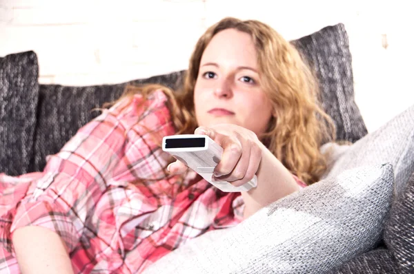 Giovane donna sta usando un telecomando — Foto Stock