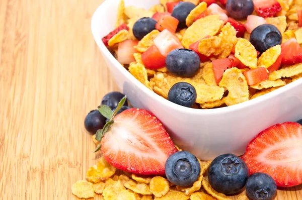 stock image Cornflakes with fruits on wood