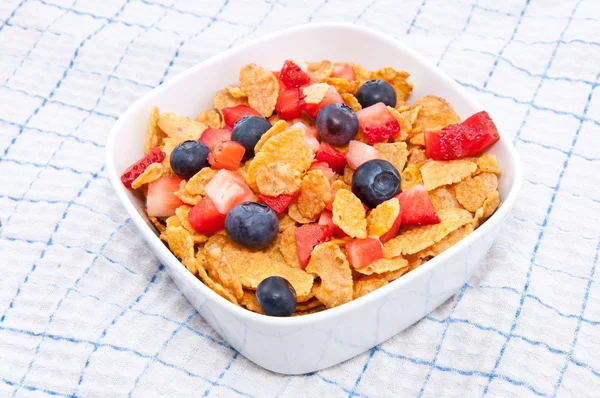 Cornflakes with fresh fruits on a tablecloth — Stock Photo, Image