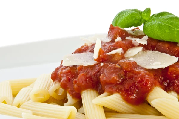 Penne con salsa, basilico e chese su un piatto (macro vista ) — Foto Stock
