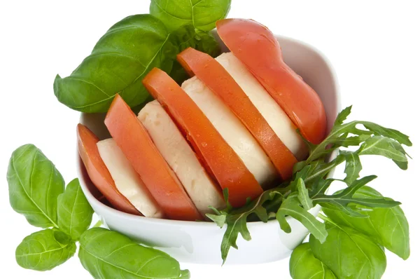 stock image Sliced tomato, mozzarella and fresh basil served in a bowl