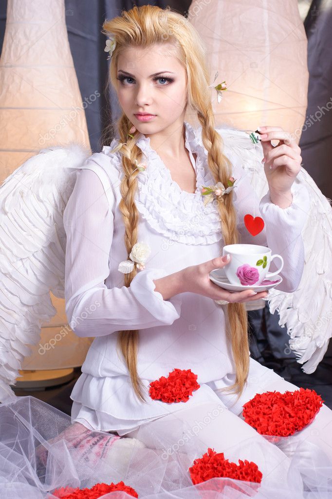 Young beauty girl angel holding a cup