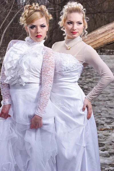 Two young women in white dresses in the winter forest — Stock Photo, Image