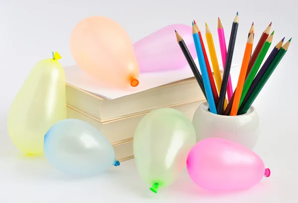 Ballonnen, boeken en potloden op een witte achtergrond — Stockfoto