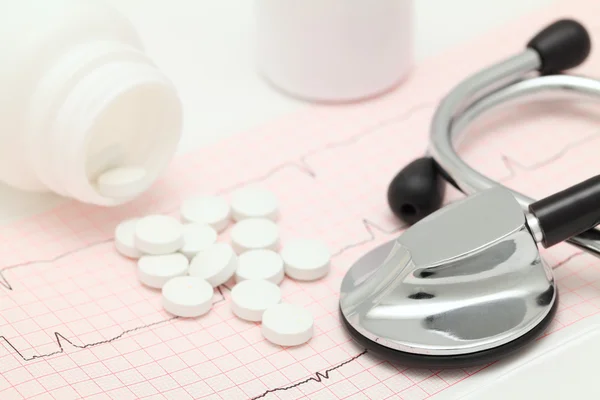 Медицинский натюрморт с кардиограммой, стетоскопом и таблетками — стоковое фото