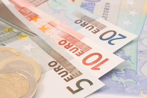 Notas e moedas de euro sobre fundo branco — Fotografia de Stock