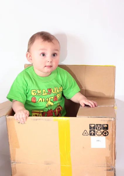 Kid climbs out of the box — Stock Photo, Image
