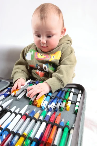 Criança escolhe uma caneta — Fotografia de Stock