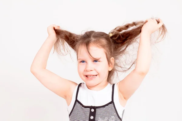 Vacker liten flicka håller sitt hår — Stockfoto