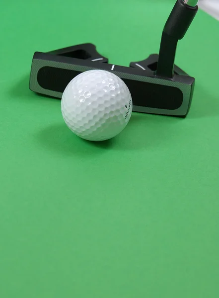 Golfklubb med bollen på green Stockbild
