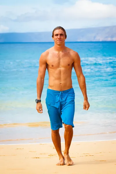 Молодой человек на тропическом пляже — стоковое фото