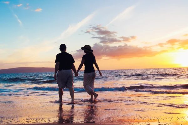 Старшая пара наслаждается закатом на пляже — стоковое фото
