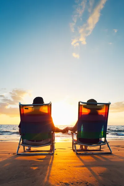 Glückliches romantisches Paar genießt schönen Sonnenuntergang am Strand Stockfoto