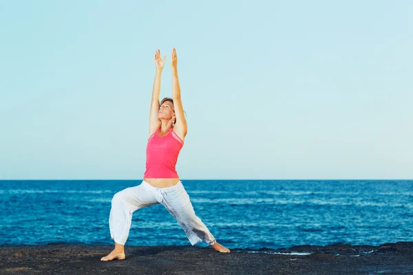 Vrouw van de prachtige yoga beoefenen van yoga door de Oceaan — Stockfoto