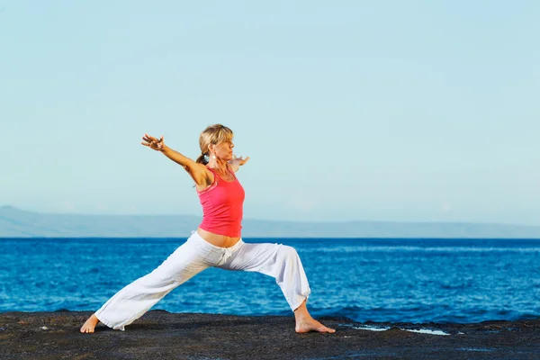 Vrouw van de prachtige yoga beoefenen van yoga door de Oceaan — Stockfoto