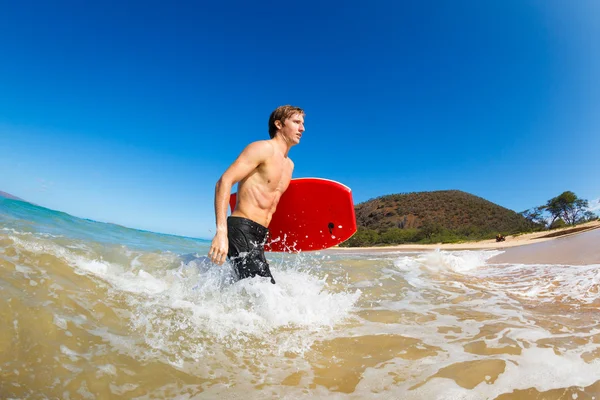 Ung man med boogie board på stranden — Stockfoto