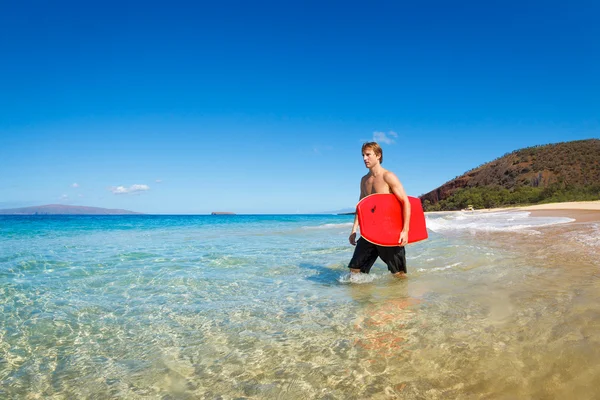 Jonge man met boogie bord op het strand — Stockfoto