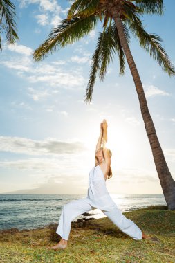 Gün batımında yoga yapan kadın.