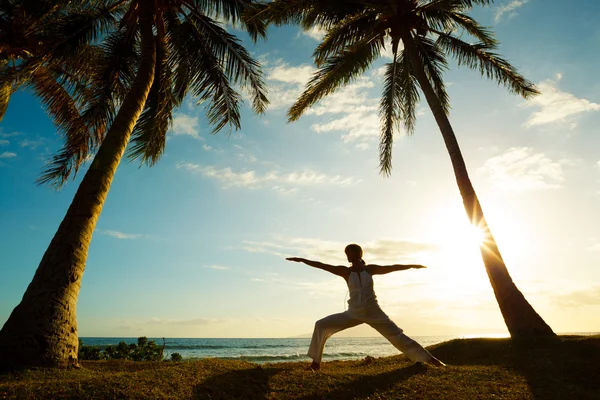 Жінка робить йогу на заході сонця — стокове фото