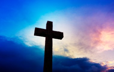 Cross against sunset sky clipart