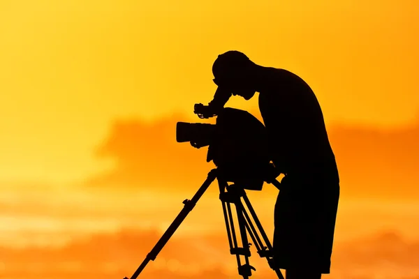 Камеру людини, професійний кінооператор на заході сонця — стокове фото