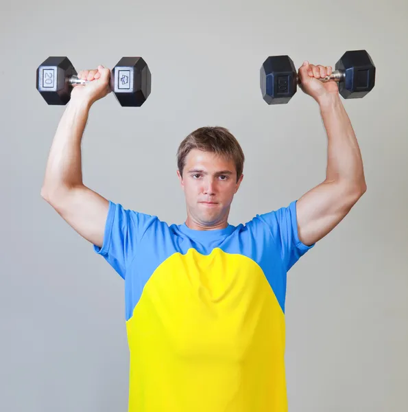 Atletische man tillen gewichten in de sportschool — Stockfoto