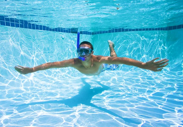 Hombre joven nadando en la piscina submarina — Foto de Stock