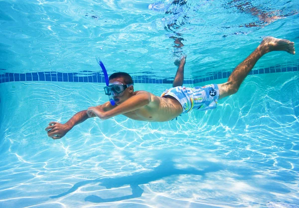 Jonge man zwemmen in zwembad onderwater — Stockfoto
