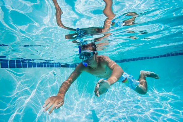 Jonge man zwemmen onder water in het zwembad — Stockfoto