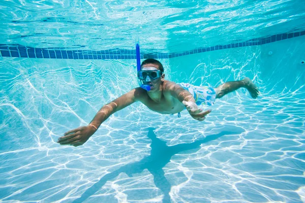 Jovem nadando debaixo de água na piscina — Fotografia de Stock