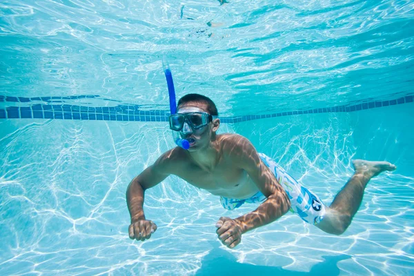 A fiatalember a medence víz alatti úszás — Stock Fotó