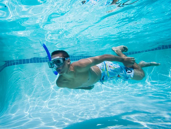 Giovane uomo nuotare sott'acqua in piscina — Foto Stock