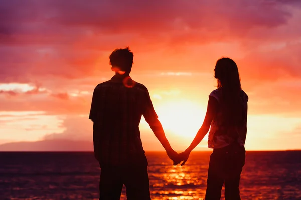 日没時の若者のロマンチックなカップルのシルエット — ストック写真