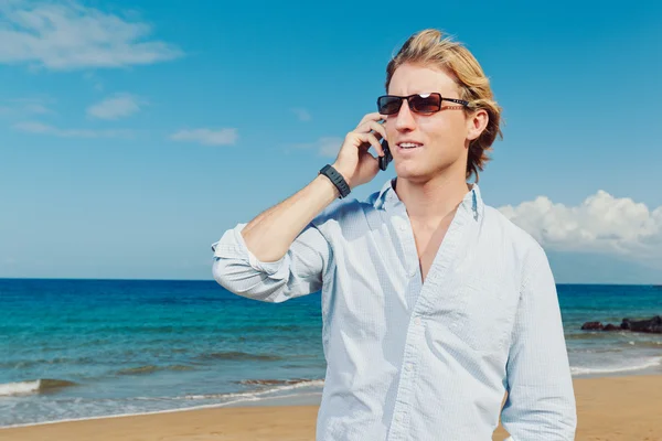 Obchodní muž volá mobilním telefonem na pláži — Stock fotografie