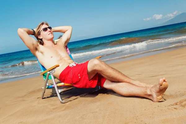 Retrato de un joven tranquilo relajándose en la playa — Foto de Stock