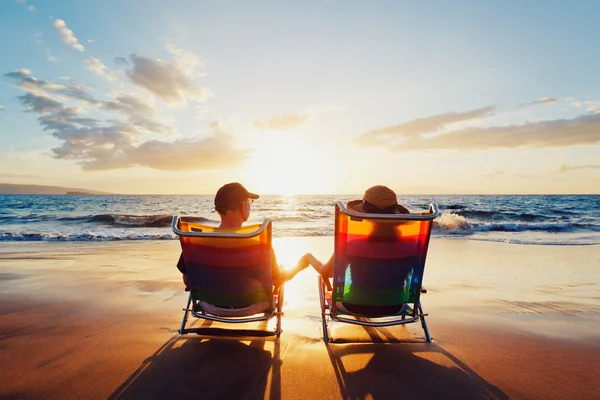 Glückliches romantisches Paar genießt schönen Sonnenuntergang am Strand Stockfoto