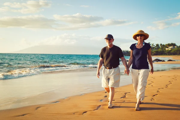 Starší pár, kteří požívají západ slunce na pláži — Stock fotografie
