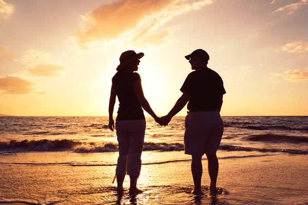 Senior koppel genieten van de zonsondergang op het strand — Stockfoto