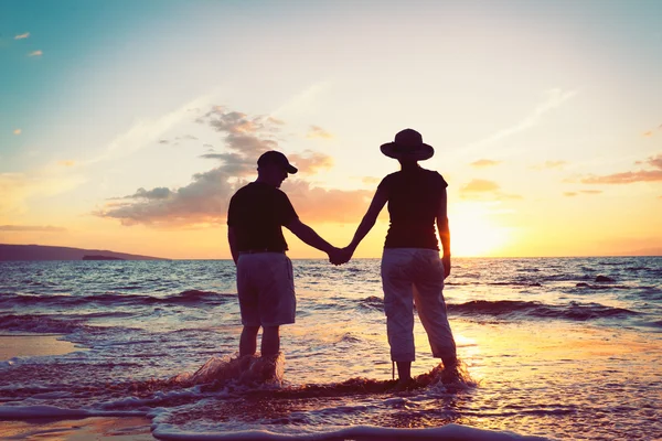 Couple aîné profitant du coucher de soleil à la plage — Photo