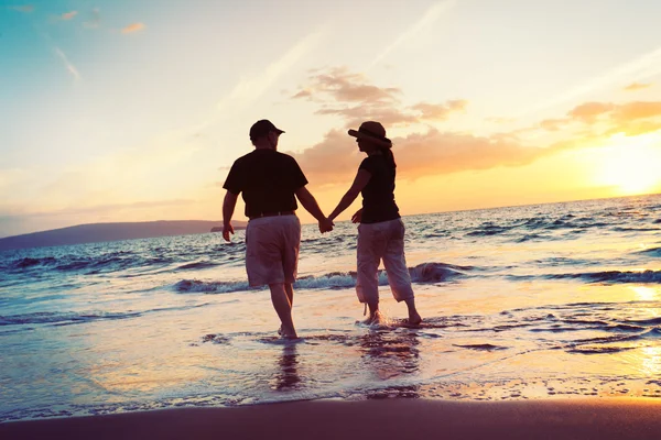 Ανώτερος ζευγάρι απολαμβάνοντας το ηλιοβασίλεμα στην παραλία — Φωτογραφία Αρχείου