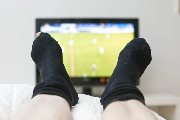 yatakta döşeme ve karanlık çorap bir delik ile oyunda TV izlerken