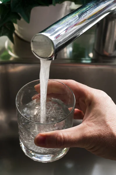 Takiing ett glas vatten från en kran — Stockfoto